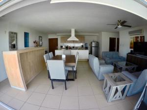 a living room and kitchen with a table and chairs at 3 Bedroom Apartment at La Joya Hotel Zone in Puerto Vallarta