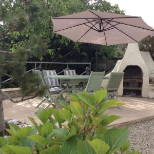 a patio with a table and chairs and an umbrella at PEGASUS in Blainville-sur-Orne