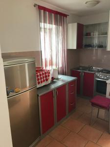 eine Küche mit roten Schränken und einem roten Stuhl darin in der Unterkunft Apartment in family house Linda in Čavle