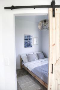 a bed in a bedroom with a wooden door at Studio 33 Władysławowo in Władysławowo