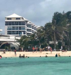 a group of people on a beach with a building at Blue Reef in San Andrés