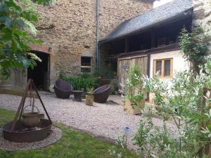 a garden with pots in front of a building at La Ferme Les Mamours in La Bastide-lʼÉvêque