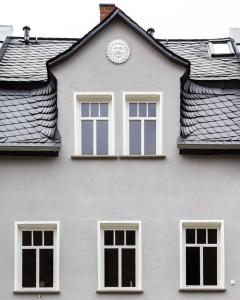 a white house with a clock on the roof at HAUS RHEINLEBEN in Boppard