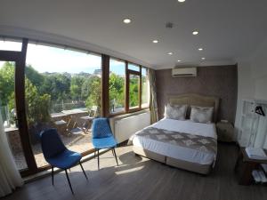 a bedroom with a bed and two blue chairs at Meydan Suites in Istanbul