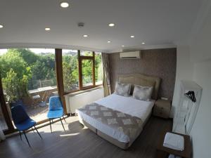 イスタンブールにあるメイダン スイーツのベッドルーム1室(ベッド1台、青い椅子2脚付)