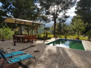 un patio con mesa y sillas junto a una piscina en Villa Claudine, en Albiol