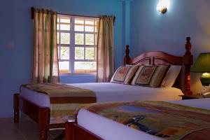 a bedroom with two beds and a window at Black Orchid Resort in Burrell Boom