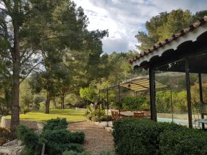 un jardín con cenador junto a un parque en Villa Claudine, en Albiol