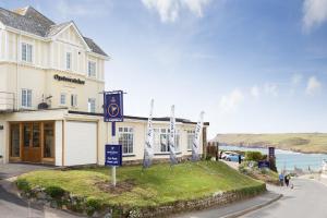 a hotel with a sign in front of a building at Oystercatcher Apartments in Polzeath