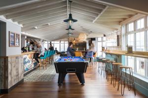 a pool table in a room with a bar at Oystercatcher Apartments in Polzeath