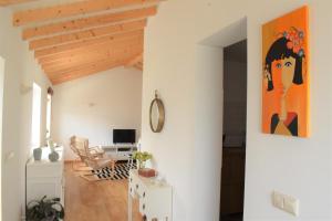 ein offenes Wohnzimmer mit einem Gemälde an der Wand in der Unterkunft Casa da Romeira in Ponte de Lima