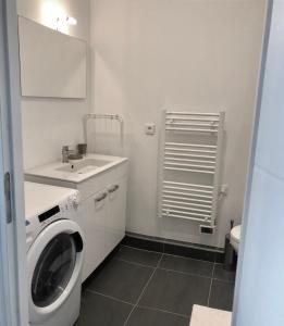 a white bathroom with a washing machine and a sink at Cannes la bocca appartement in Cannes