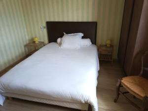 a bed with white sheets and pillows in a room at Hôtel de la Poste Chez Cécile in La Grande-Verrière