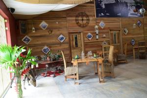 Habitación con pared de madera, mesa y sillas. en Hotel Rio Celeste Finca L´ Etoile Celeste en El Achiote