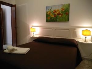 a bedroom with a bed with two lamps and a painting at Josephine Holidays in Lecce