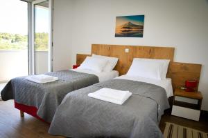 een kamer met twee bedden met handdoeken erop bij Apartments Novak in Rab +42 foto's