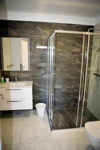 een badkamer met een douche, een toilet en een wastafel bij Apartments Novak in Rab