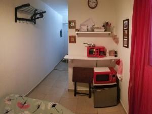 a small kitchen with a red microwave on a table at Aché Tropical Studio@white-Red in San Juan