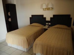 Postel nebo postele na pokoji v ubytování Hotel Hacienda Nainari