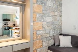 a living room with a stone wall and a mirror at Electra Houses in Stoupa