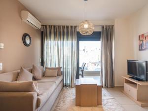 a living room with a couch and a television at Onyx City Center Apartment in Heraklio