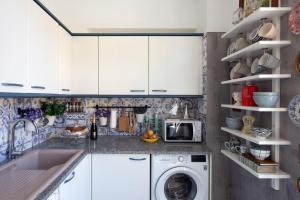 a kitchen with white cabinets and a washer and dryer at LovelyStay - Casa do Papel - Charm in Matosinhos in Matosinhos