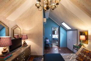 ein Schlafzimmer im Dachgeschoss mit blauen Wänden und Holzdecken in der Unterkunft Casa do Papel - Charm in Matosinhos in Matosinhos