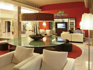 
a living room filled with furniture and a tv at Hotel Mercure Figueira Da Foz in Figueira da Foz
