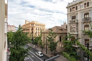 a city street with buildings and a car parked on the street at Gran Vía Luxury 3BR in Granada