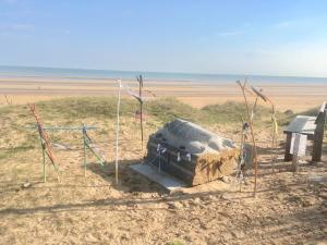 a fire pit on the beach next to the ocean at Villa kahlo Omaha Beach in Colleville-sur-Mer