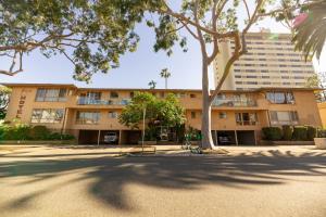 a large building with a tree in front of it at Cal Mar Hotel Suites in Los Angeles