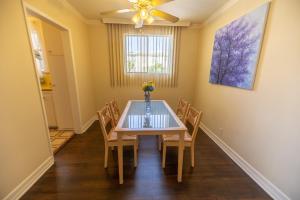 a dining room with a table with chairs and a ceiling fan at Cal Mar Hotel Suites in Los Angeles