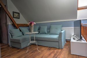 ein Wohnzimmer mit einem blauen Sofa und einem Tisch in der Unterkunft Warmińska Winnica in Barczewo