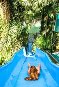 Una niña se desliza por un tobogán azul en Baldi Hot Springs Hotel & Spa en Fortuna