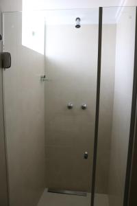 a shower with a glass door in a bathroom at Hotel Capuchins in Porto Seguro