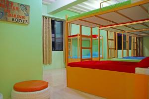 a bedroom with two bunk beds and a stool at Antwet Backpacker's Inn & Rooftop Bar in Dumaguete