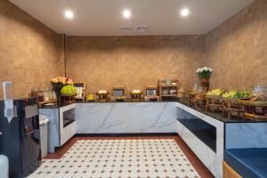 a kitchen with marble counter tops and tables at Anumat Premium Budget Hotel in Chiang Mai