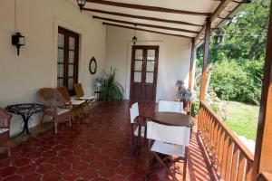 un porche de una casa con mesa y sillas en Hostal El Cerrito San Lorenzo en San Lorenzo