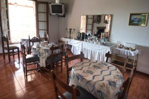 comedor con mesas, sillas y espejo en Hostal El Cerrito San Lorenzo en San Lorenzo