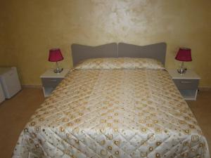a bedroom with a bed with two nightstands and two lamps at B&B Casa Murgiana in Gravina in Puglia