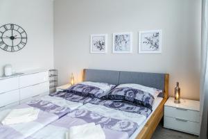 1 dormitorio con 1 cama con sábanas moradas y blancas en The Town Hall Residence -Welcome Home Apartment-free outdoor parking-AC, en Košice