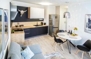 a kitchen and living room with a table and chairs at The Town Hall Residence -Welcome Home Apartment-free outdoor parking-AC in Košice