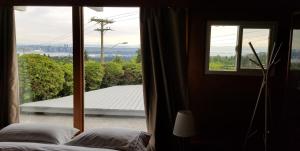 a bedroom with a window with a view of a roof at City Gardens Suites B&B in North Vancouver