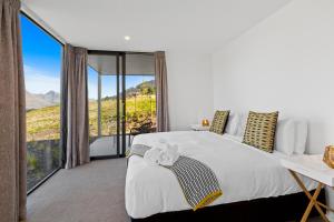 1 dormitorio con cama grande y ventana grande en Peak View Residence, en Queenstown