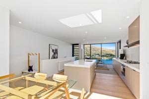 a kitchen and dining room with a table and chairs at Peak View Residence in Queenstown