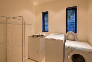 a bathroom with a washing machine and a sink at Majestic View Home in Queenstown