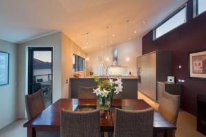 comedor y cocina con mesa y sillas en Majestic View Home, en Queenstown