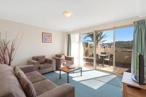 a living room filled with furniture and a tv at Black Dolphin Motel & Apartments in Merimbula