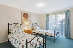 a bedroom with a bed and a desk at Black Dolphin Motel & Apartments in Merimbula