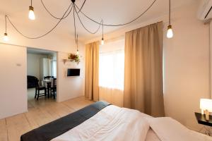 a bedroom with a bed and a dining room at Antic Apartments in Bucharest